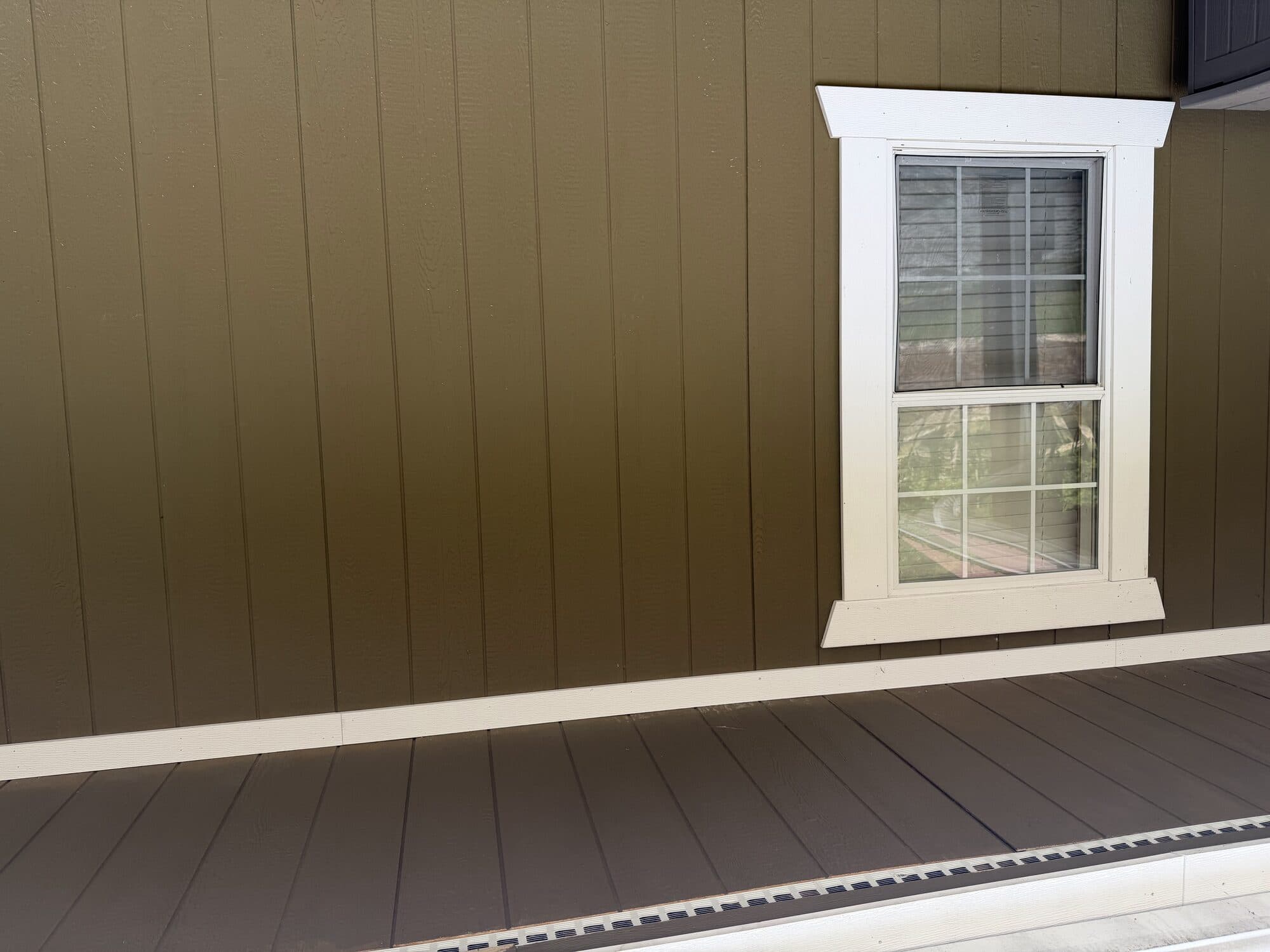 Painted exterior siding with white window trim