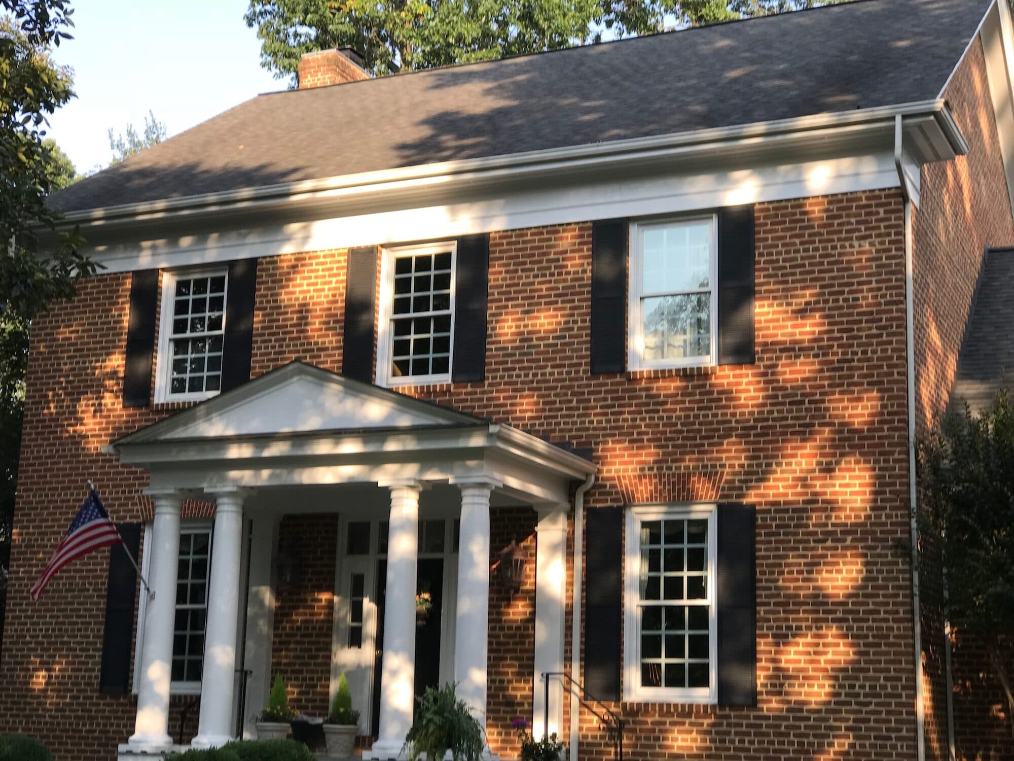 Painted exterior trim and portico on a brick home
